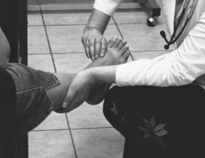 A doctor examining the foot of a patient at hospital