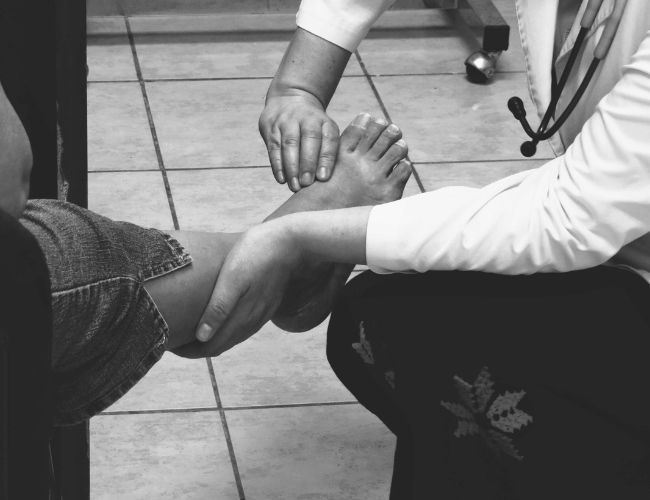 A doctor examining the foot of a patient at hospital