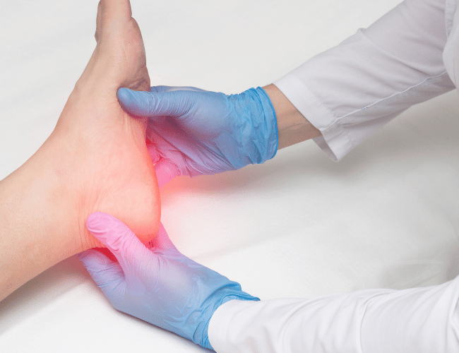 A doctor examining a patient's foot for fat pad atrophy pain and diagnosis
