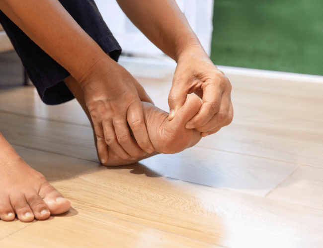 A patient pressing their leg due to bursitis foot pain