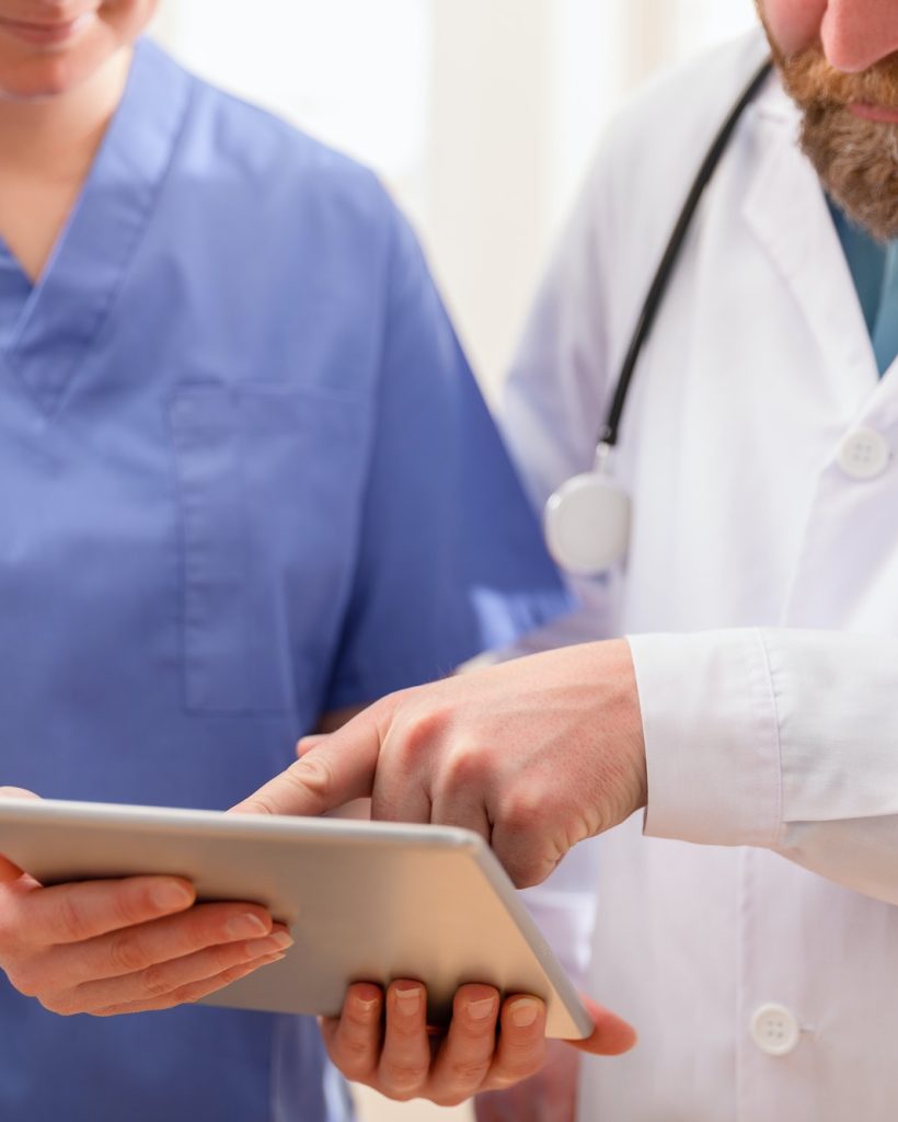 doctor-and-nurse-discussing-patients-tests-at-tablet-computer-in-hospital.jpg